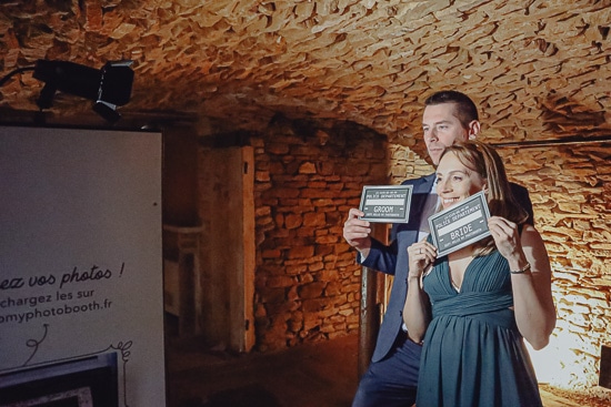 Couple qui pose devant le photobooth pour un mariage dans le beaujolais